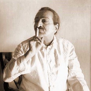 Meher Baba, his finger raised to his lips in silence