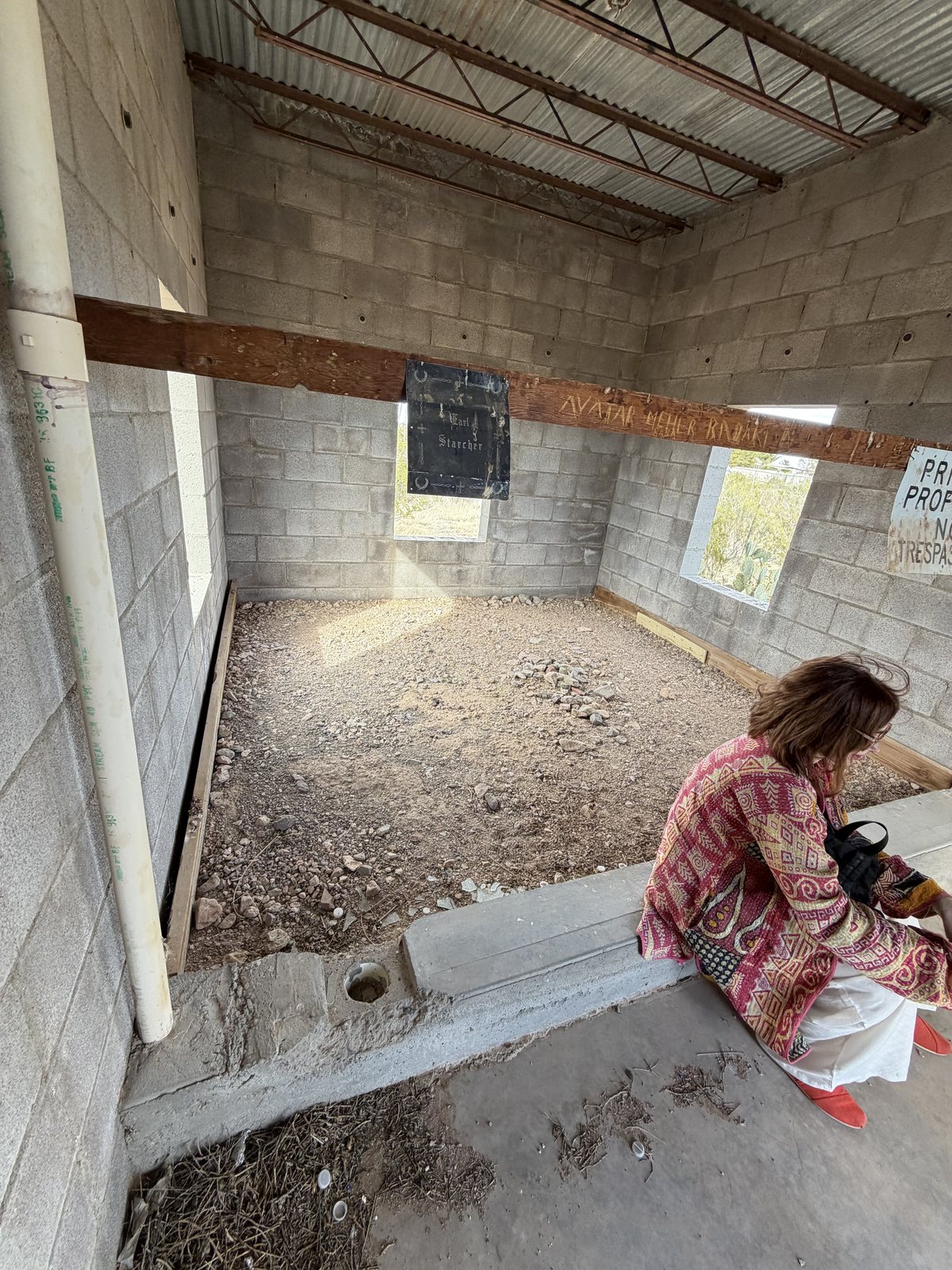 Inside the shrine: bare cinder-block walls, a dirt floor and notices posted on the wall